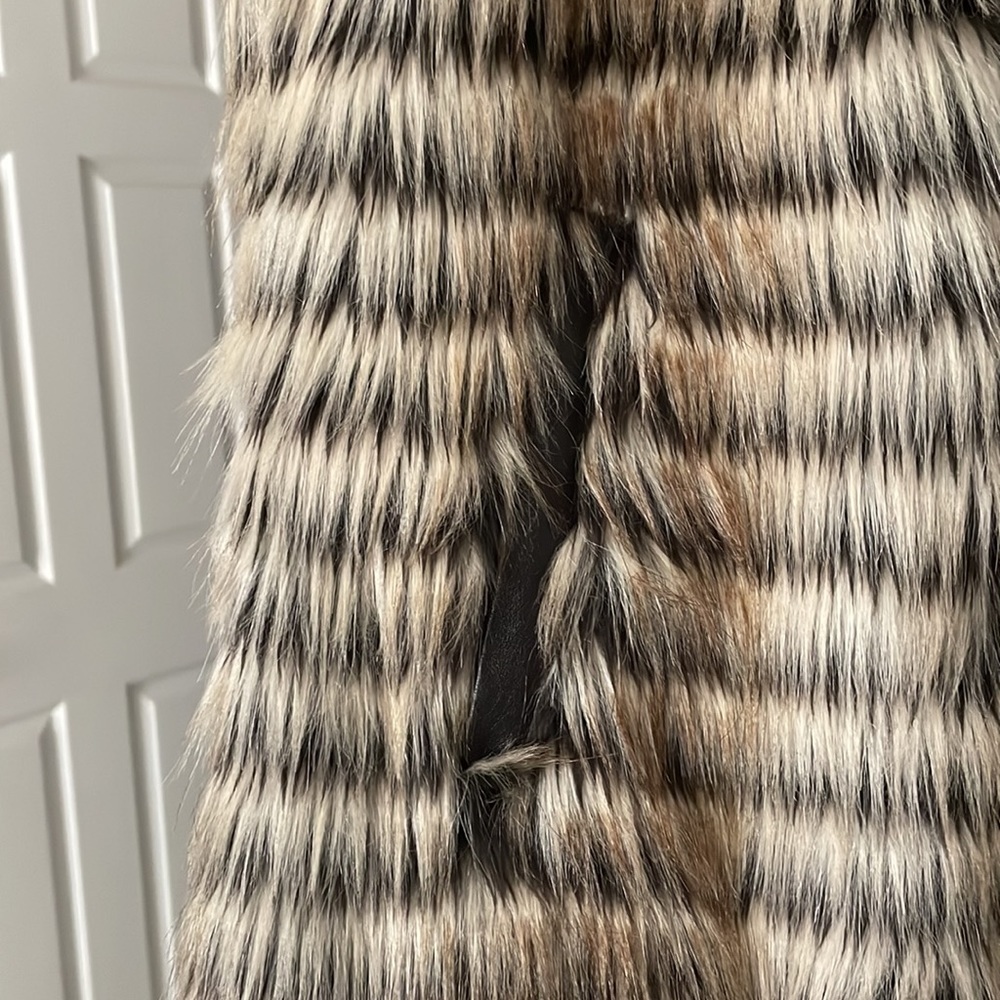 Furry vest faux fur has leather side on zipper and pockets